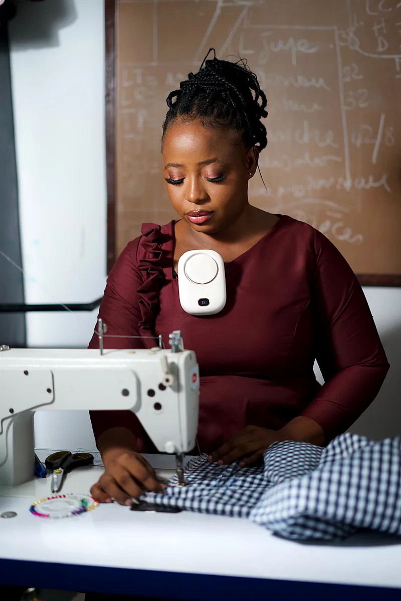 Couture à l'atelier devant un tableau de patronage